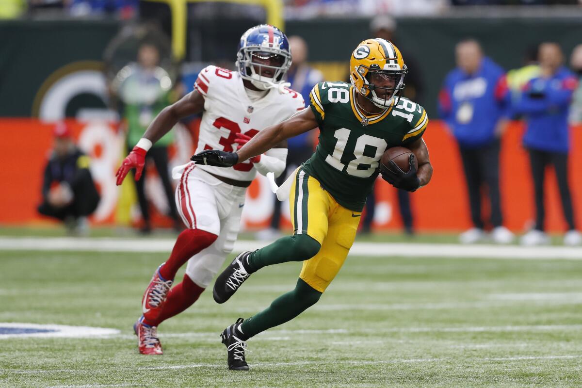 Green Bay Packers wide receiver Randall Cobb runs after a reception while New York Giants cornerback Darnay Holmes chases.