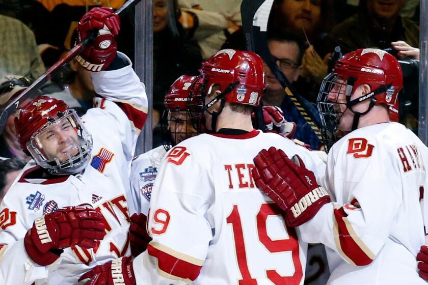 Denver left wing Jarid Lukosevicius (14), left, celebrates with teammates after scoring his goal against Minnesota-Duluth during the second period of an NCAA Frozen Four championship college hockey game, Saturday, April 8, 2017, in Chicago. (AP Photo/Nam Y. Huh)
