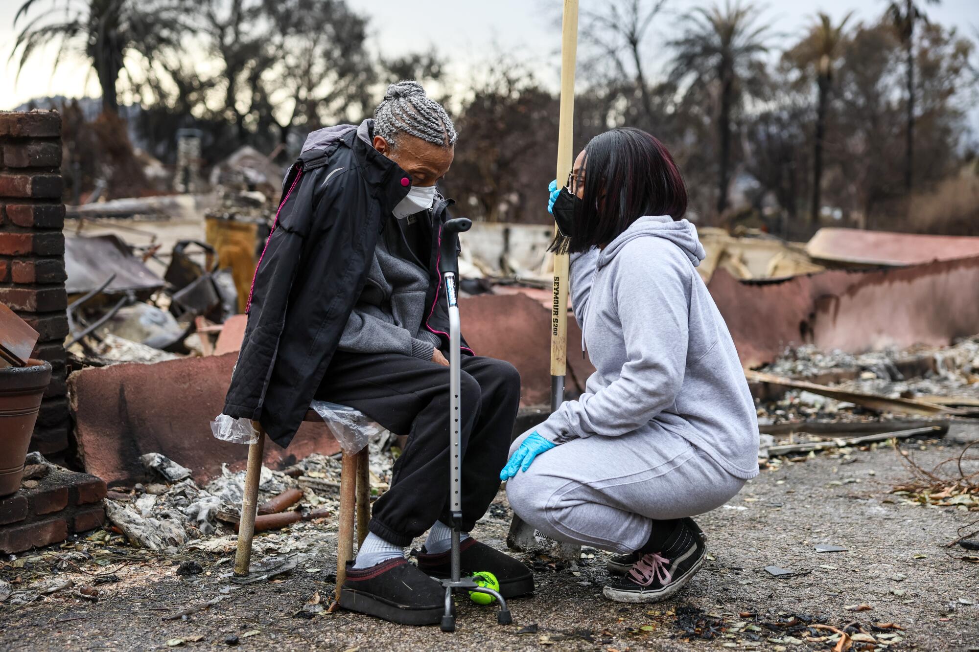 Lashonda Ellis comforts her grandmother, Margaret Martin as she sits outside a home built by her husband in 1966.