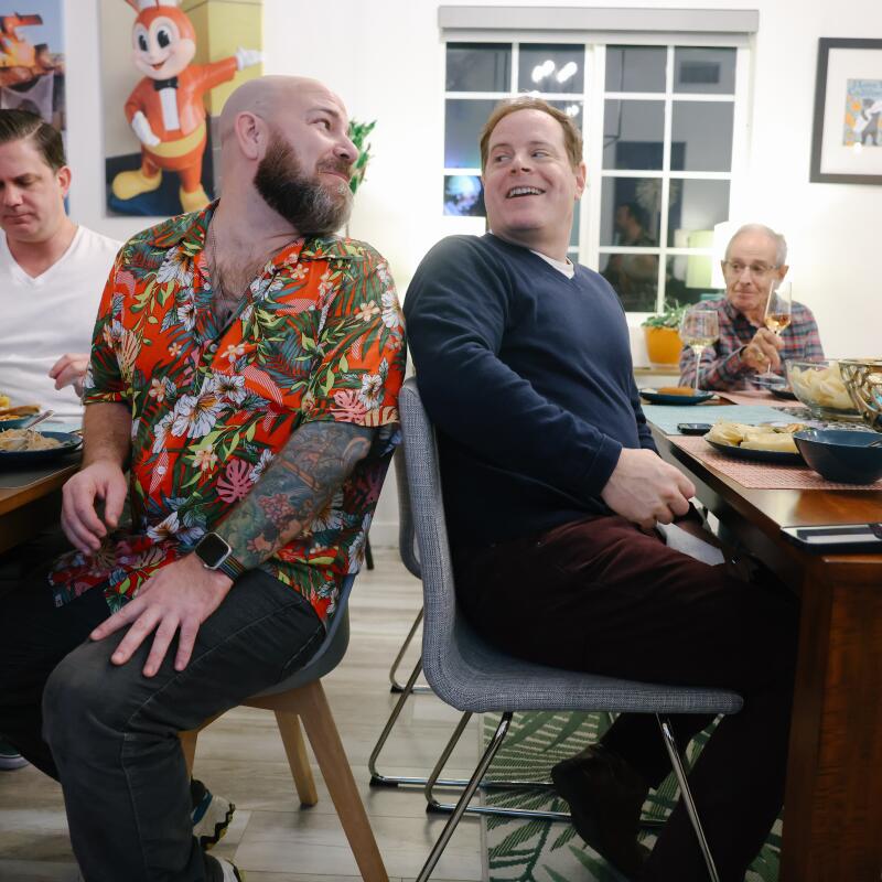 Damian White, left, and Todd Sokolove, right, chat during a Nochebuena celebration on Christmas Eve at their home.