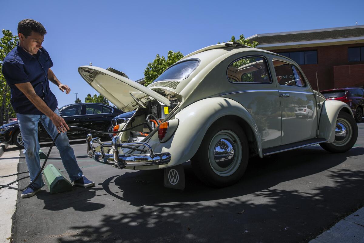 Man charges electric VW Beetle