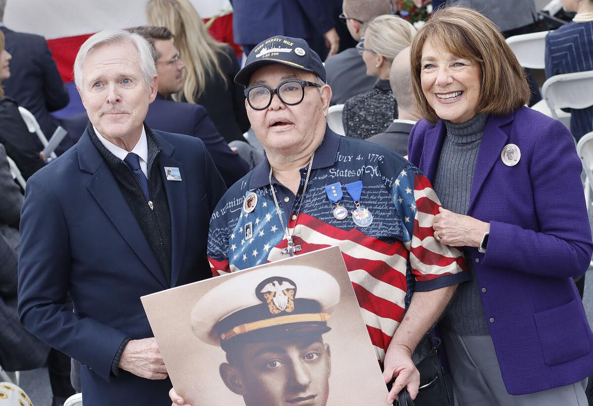 From left, Ray Mabus, Nicole Murray-Ramirez and Susan Davis with a photo of Lt. Harvey Milk.