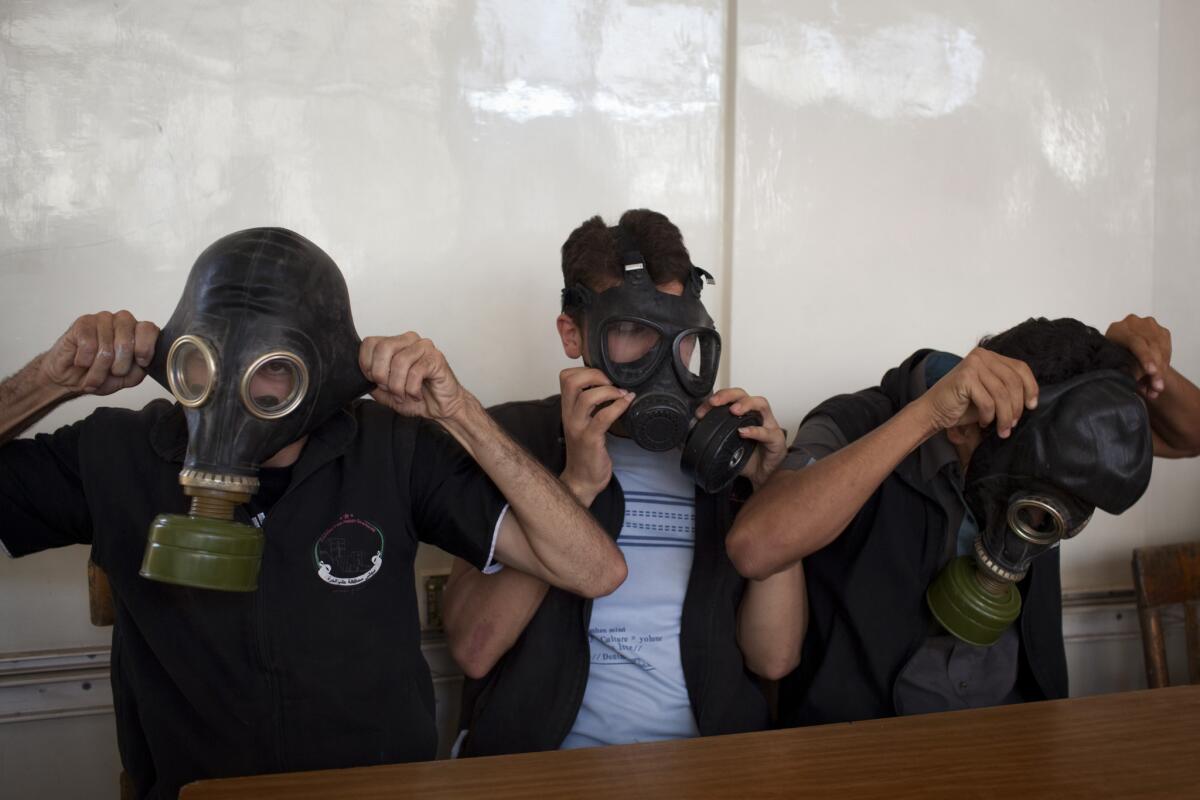 Volunteers put on gas masks during a class on how to respond to a chemical attack in the northern Syrian city of Aleppo.