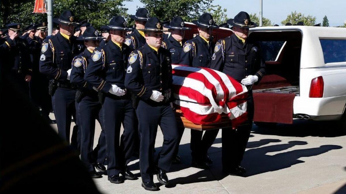 The flag-draped casket of Sacramento police Officer Tara O'Sullivan is carried into church for a memorial service in Roseville, Calif., on Thursday.
