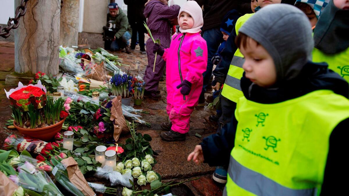 Children lay down flowers in front of Fredensborg Palace after Prince Henrik died Tuesday.