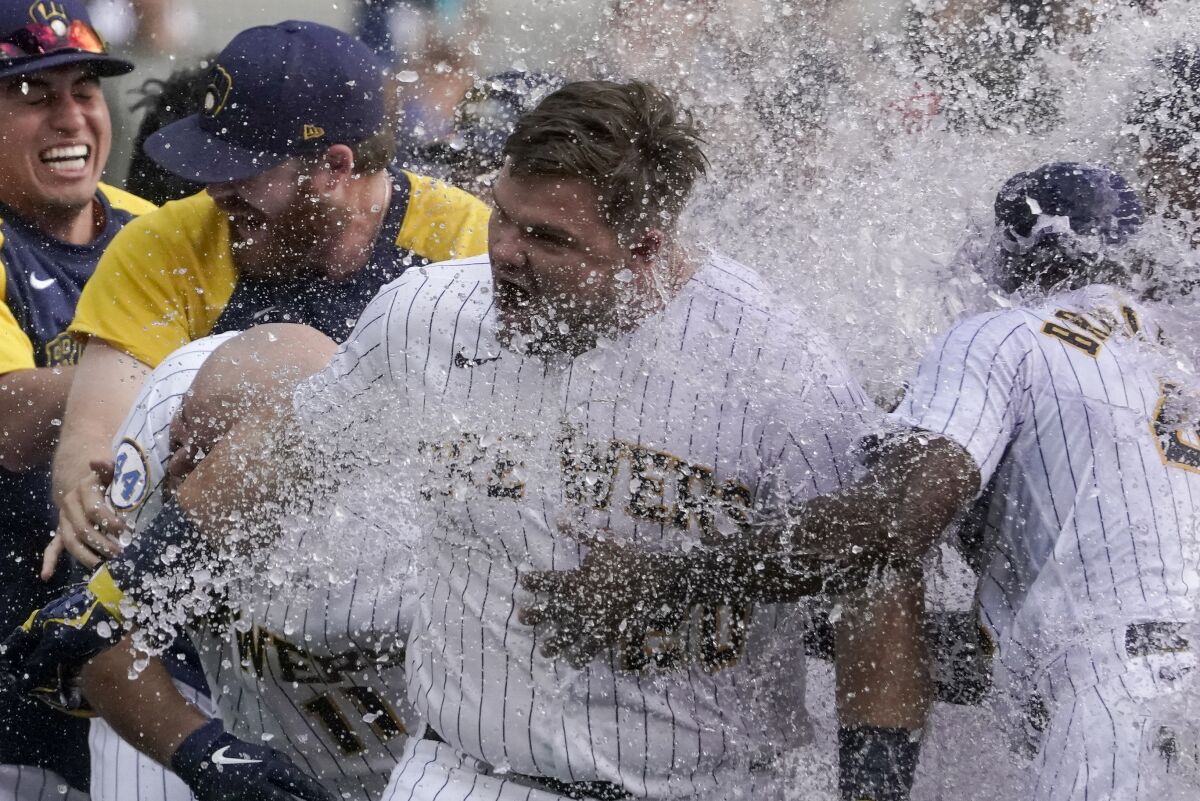 Milwaukee Brewers' Daniel Vogelbach is congratulated by teammates after hitting a walk-off grand slam during the ninth inning of a baseball game against the St. Louis Cardinals Sunday, Sept. 5, 2021, in Milwaukee. The Brewers won 6-5. (AP Photo/Morry Gash)