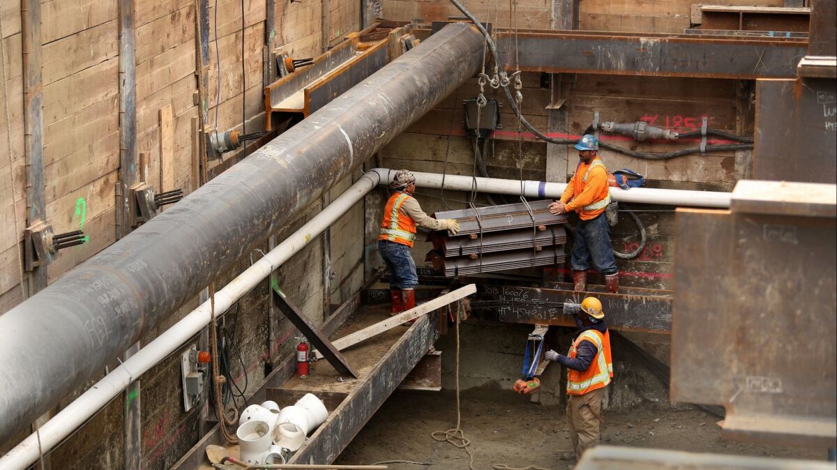 Crews work on an extension of the Metro Purple Line at Wilshire Boulevard and La Brea Avenue. A California bill would allow four- to eight-story residential buildings at properties near rail stations and major bus stops.