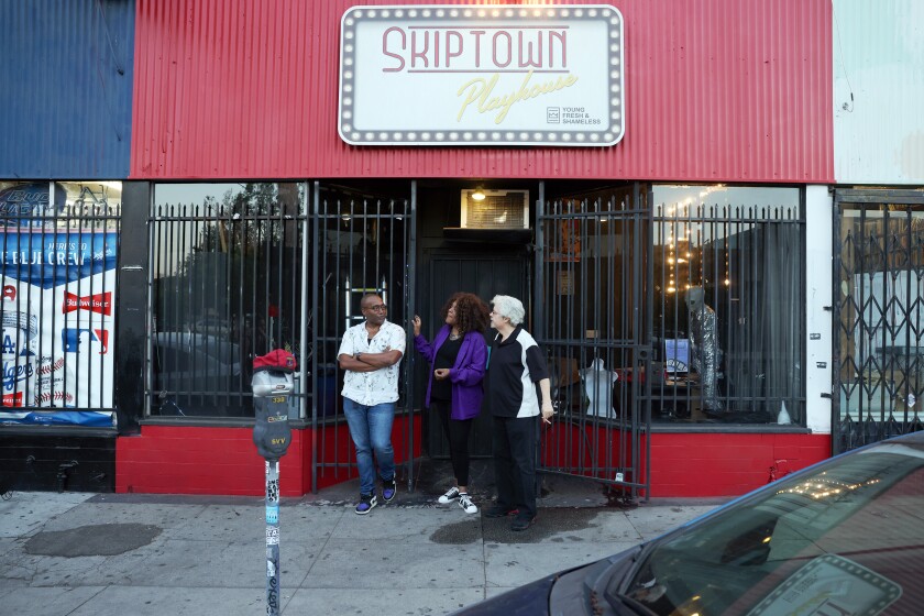 Three people hang outside of Skiptown Playhouse