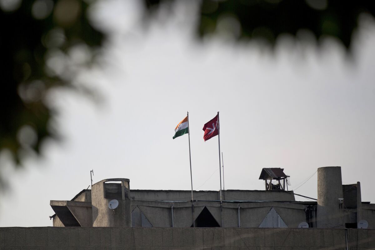 FILE - In this Aug. 9, 2019, file photo, an Indian national flag, left, is hoisted next to a Jammu and Kashmir state flag on the government secretariat building after New Delhi scrapped the disputed region’s semi-autonomy in Srinagar, Indian controlled Kashmir. Indian-controlled Kashmir has remained on edge after New Delhi last summer scrapped the disputed region’s semi-autonomy amid a near-total clampdown. While deeply unpopular in Muslim-majority Kashmir, the sudden move resonated in India, where Prime Minister Narendra Modi was cheered by supporters for fulfilling a long-held Hindu nationalist pledge. (AP Photo/Dar Yasin, File)