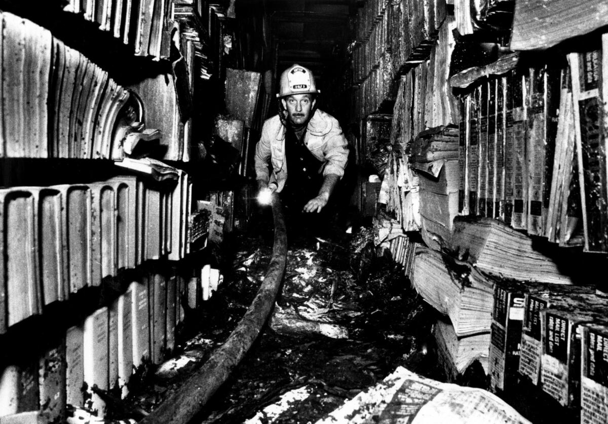 Fire Capt. Don Stukey examining the damage after the 1986 fire, which was determined to be arson.