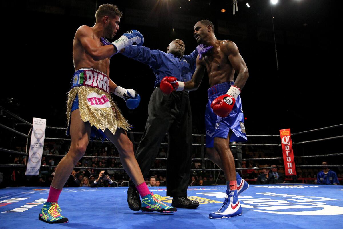 Boxers Terrel Williams and Prichard Colon, left, are seperated by the referee during their super-welterweight bout in on Oct. 17 in Fairfax, Virginia.