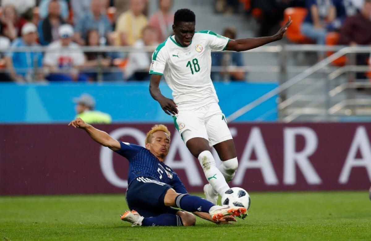 Japan's Yuto Nagatomo (5) and Senegal's Ismaila Sarr (18) battle for a ball on June 24.