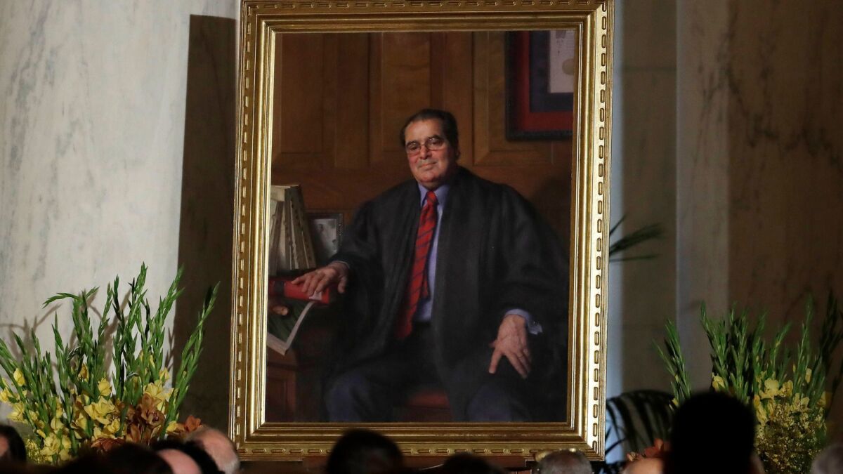 A portrait of the late Supreme Court Justice Antonin Scalia is displayed during a memorial for him held in the Great Hall of the Supreme Court building in Washington on Nov. 4, 2016. Donald Trump has promised to appoint a conservative in the mold of Scalia.