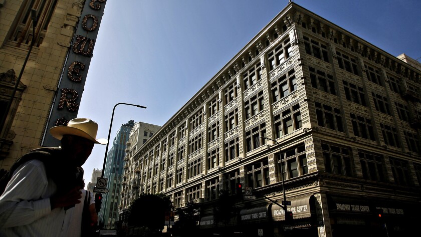 The Broadway Trade Center, at right, in downtown Los Angeles. The old department store will be converted to a combination shopping mall, office building and hotel, and will have two swimming pools, rooftop gardens and restaurants.