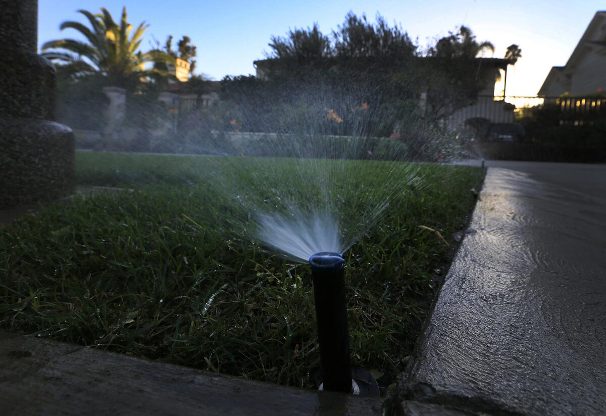 Sprinklers water a lawn at dusk in Beverly Hills. Statewide, Californians cut their urban water use in March by 24.3% compared with the same month in 2013, regulators said.