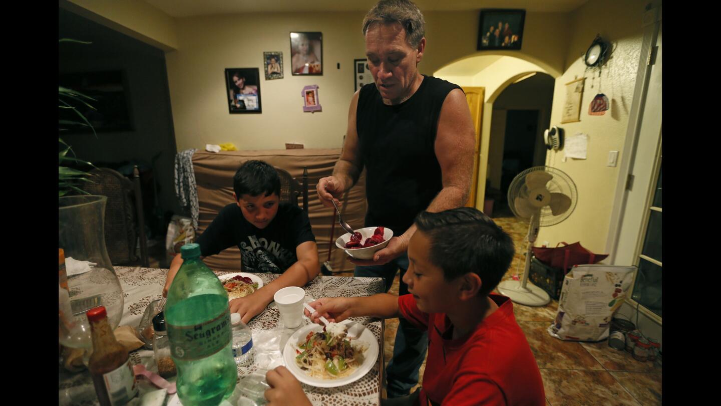 Michael Paulsen serves dinner to his sons Ryan, 12, and Brannon, 9, at their home in Vista, Calif. The automobile mechanic has been a single dad for nine years since his wife, a Mexican immigrant in the U.S. illegally, was deported.