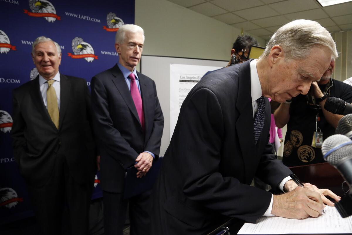 Former California Governor Pete Wilson, right, signs a document for death penalty reform in Los Angeles. Standing with Wilson are former governors Gray Davis, center, and George Deukmejian. The signature gathering efforts hope to put the reform matter before the voters in November. Davis and Deukmejian also signed.