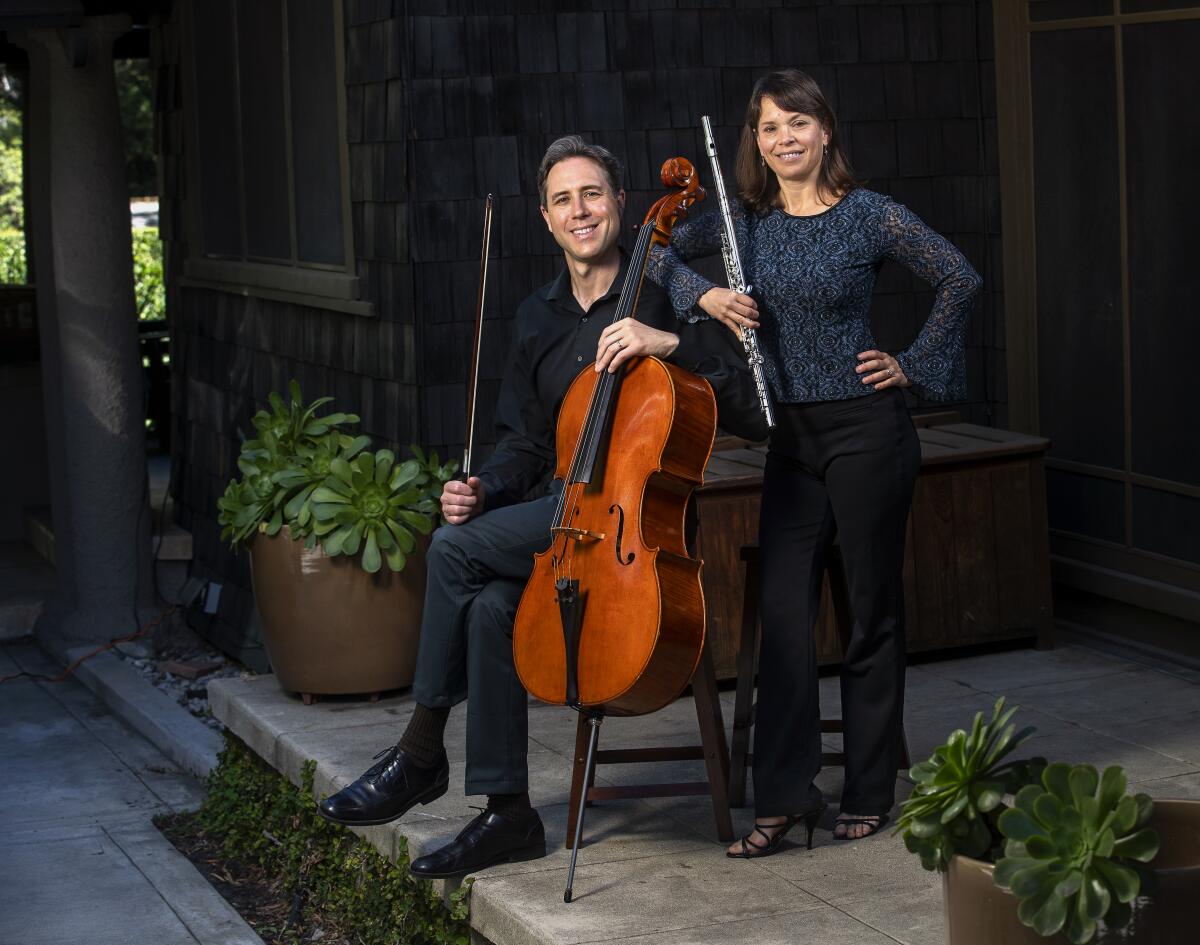 Jonathan Karoly, with cello, and Cathy Karoly, with flute, outside their home in Pasadena.