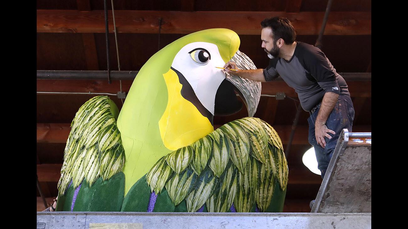 Paradiso Floats owner Charles Meier works on a giant Macaw for the Donate Life float titled The Gift of Time, at the Rosemont Pavilion building location in Pasadena on Friday, Dec. 29, 2017.