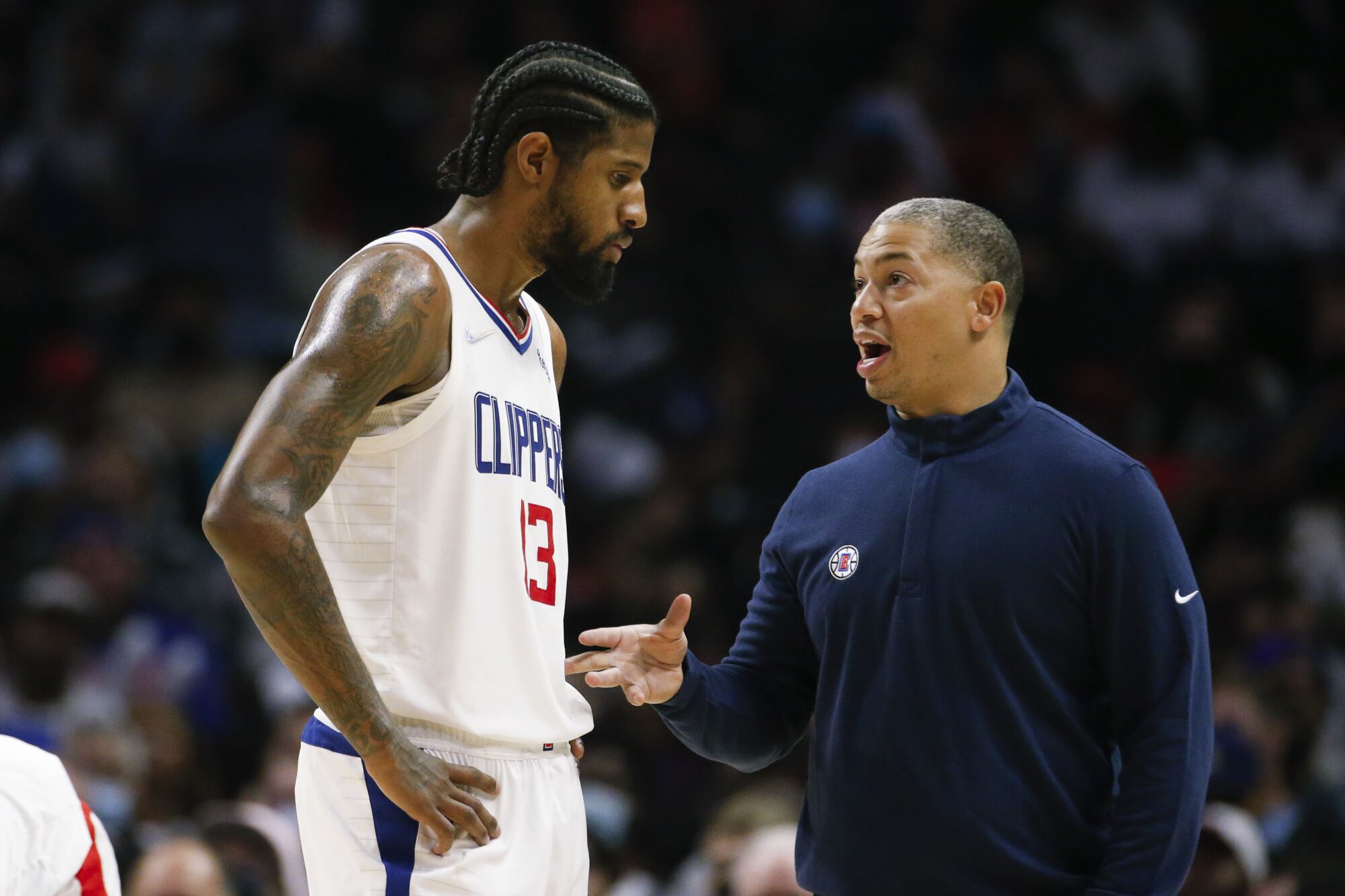 Clippers coach Tyronn Lue talks to forward Paul George during a game against the Charlotte Hornets on Nov. 7.