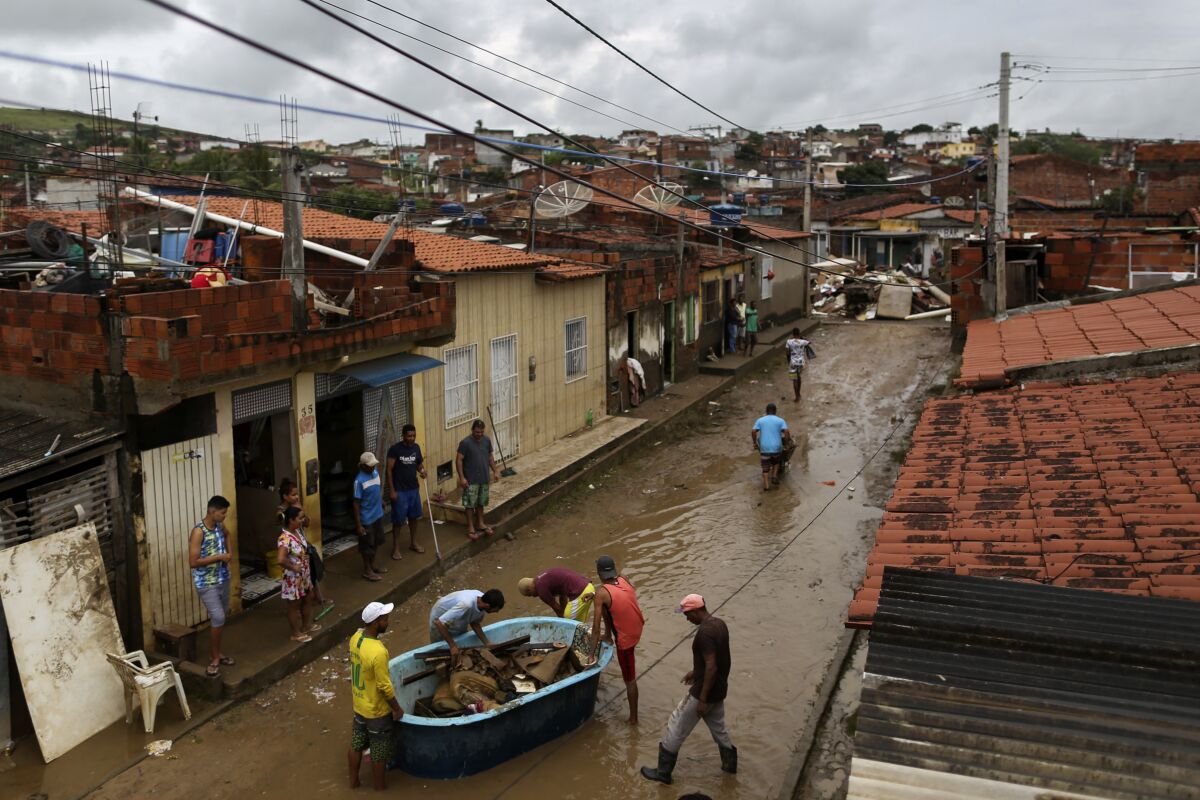 Residents clean out their flooded homes in Itapetinga, Bahia state, Brazil