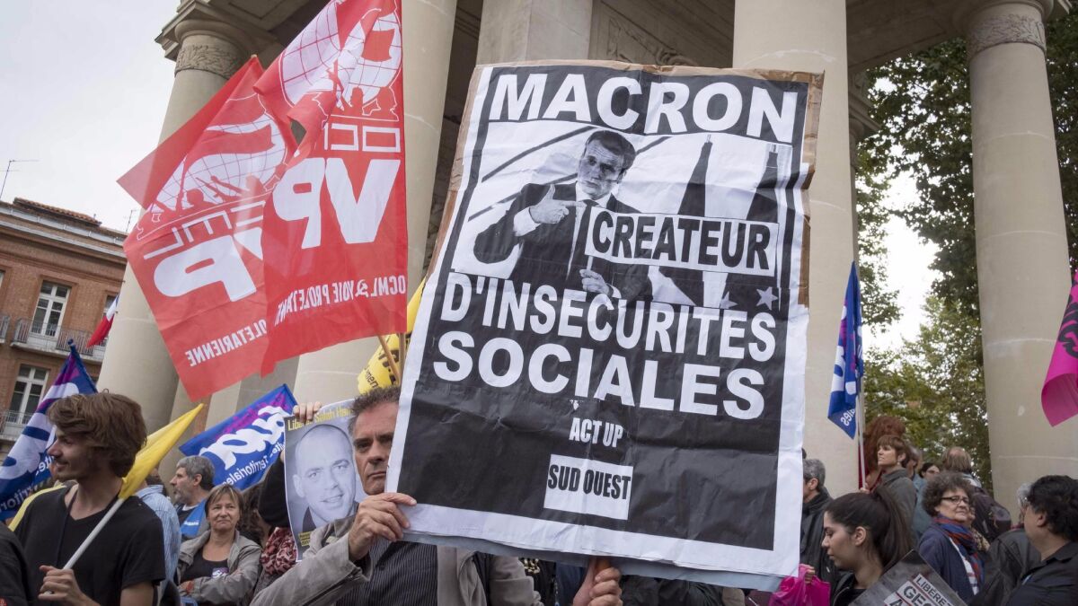 Demonstrators gather in Toulouse, France, on Monday to protest labor law reforms supported by President Emmanuel Macron. A placard reads: "Macron creator of social insecurities"