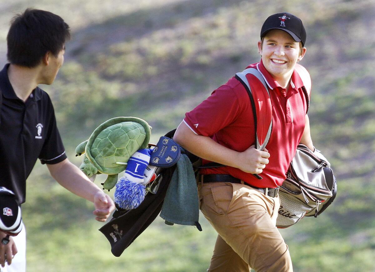 La Cañada's Robby Stehlin smiles to a teammate as he walks to his ball at practice at the La Cañada Flintridge Country Club on Tuesday, February 25, 2014.