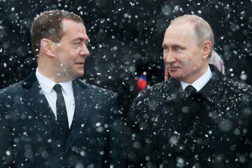 Russian President Vladimir Putin, right, and Prime Minister Dmitry Medvedev attend a wreath-laying ceremony at the Tomb of the Unknown Soldier in Moscow, Russia, Thursday, Feb. 23, 2017. The Defenders of the Fatherland Day, celebrated in Russia on Feb. 23, honors the nation's military and is a nationwide holiday. (AP Photo/Ivan Sekretarev)