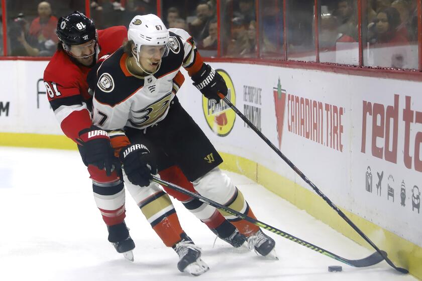 Anaheim Ducks left wing Rickard Rakell (67) and Ottawa Senators center Chris Tierney (71) battle along the boards during the first period of an NHL hockey game, Tuesday, Feb. 4, 2020 in Ottawa, Ontario. (Fred Chartrand/The Canadian Press via AP)