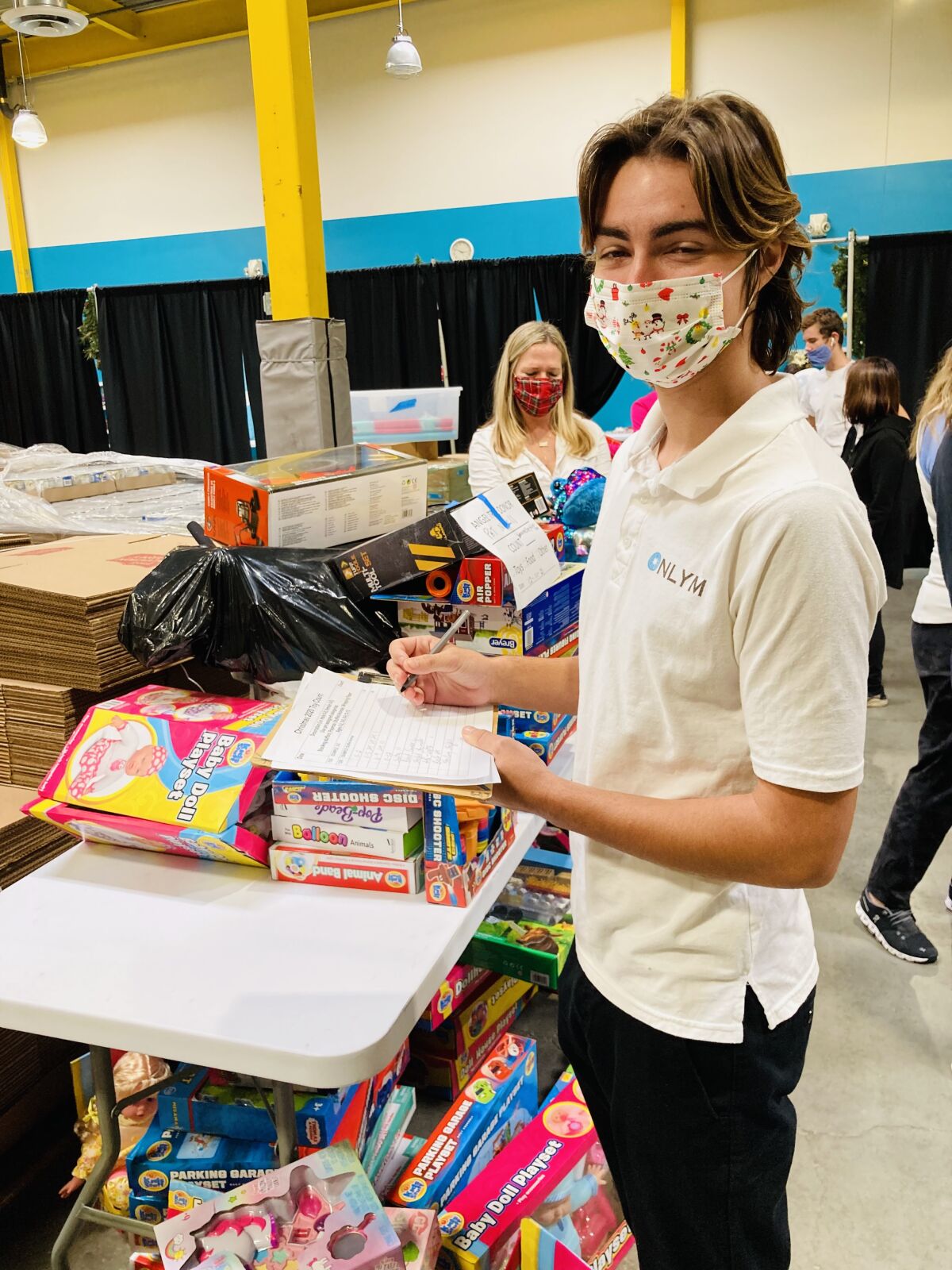 Alex Cockrell helps out as the La Jolla chapter of the National League of Young Men supported a toy and food collection.