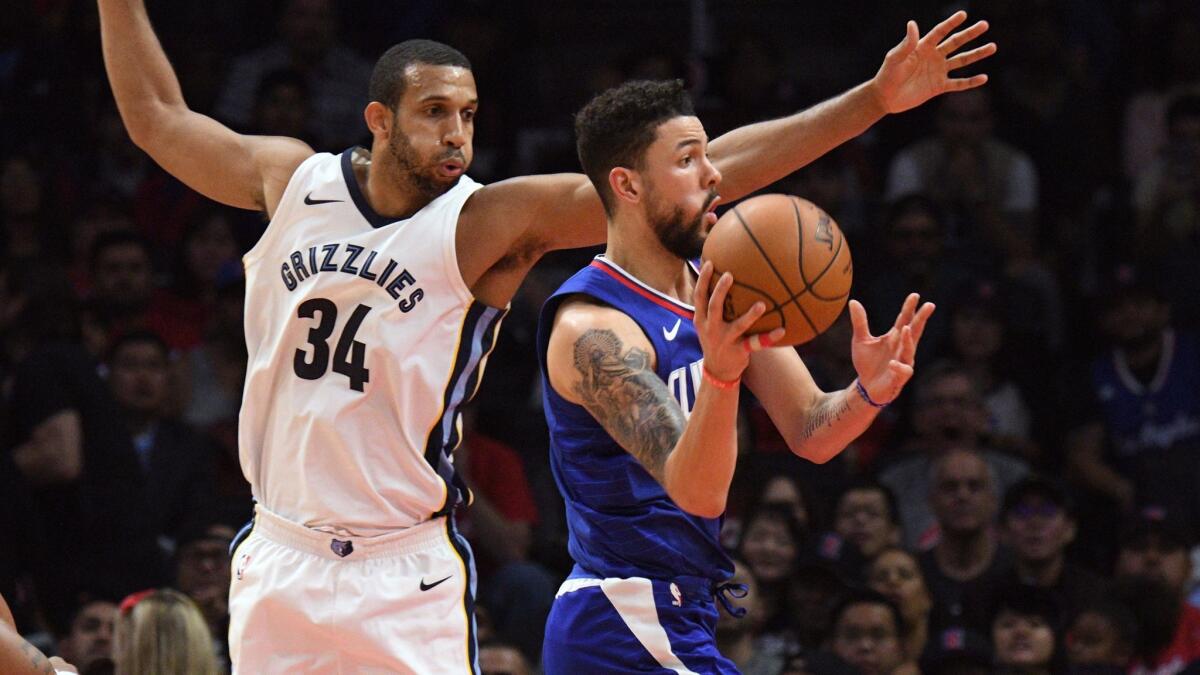 Clippers guard Austin Rivers makes a pass around Grizzlies forward Brandan Wright during their game Saturday.
