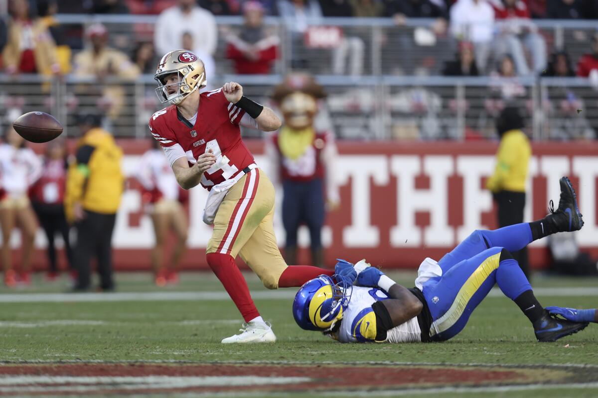 San Francisco 49ers'ın oyun kurucusu Sam Darnold (14), Desjuan Johnson'ın önünde topallıyor.