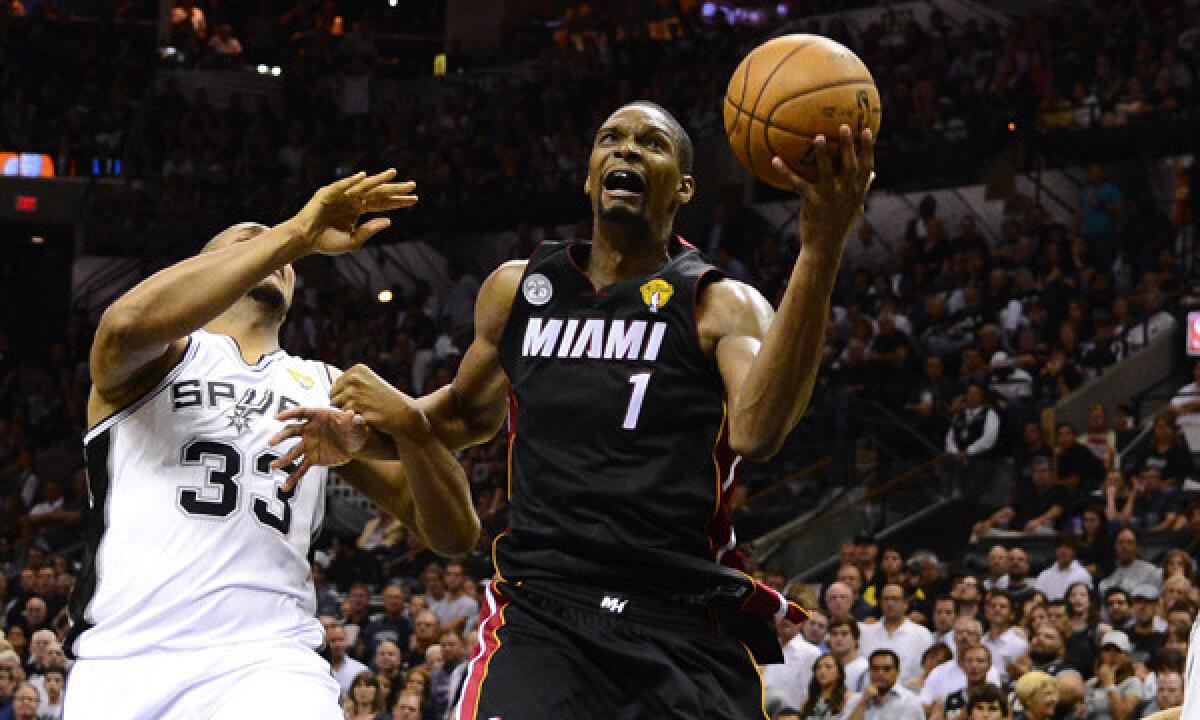 Miami Heat center Chris Bosh grabs a rebound away from San Antonio Spurs center Boris Diaw during Game 4 of the NBA Finals.
