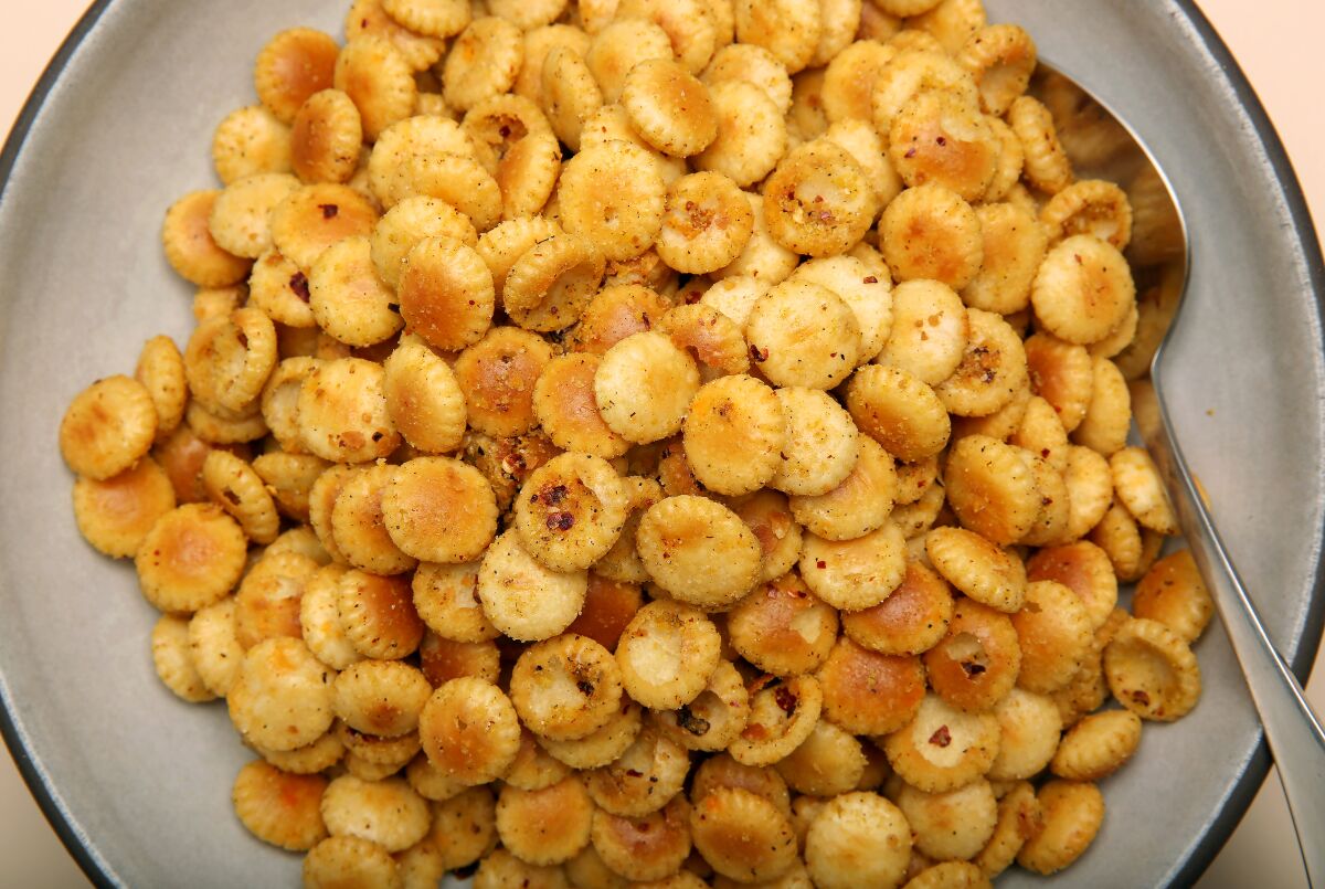 A bowl of small round crackers coated with a spice mix