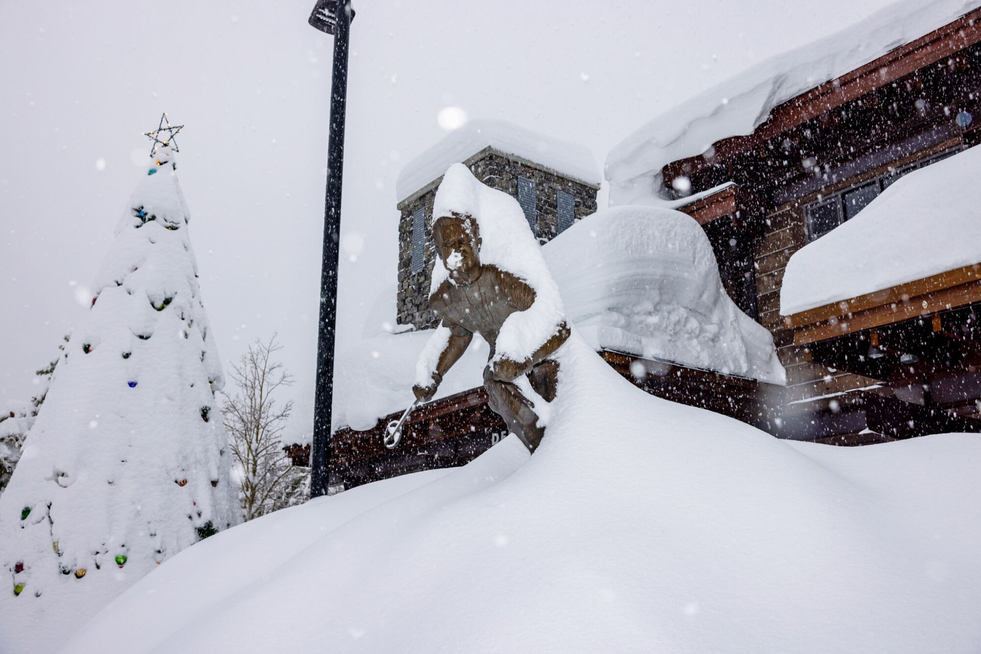 A statue of Mammoth Mountain founder Dave McCoy is buried under snow.