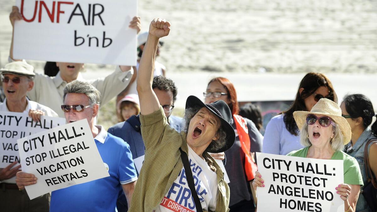 Dozens of Venice residents, advocates and affordable-housing supporters rally on the Venice Beach Boardwalk to call on the Los Angeles City Council to regulate short-term rentals in August 2015.