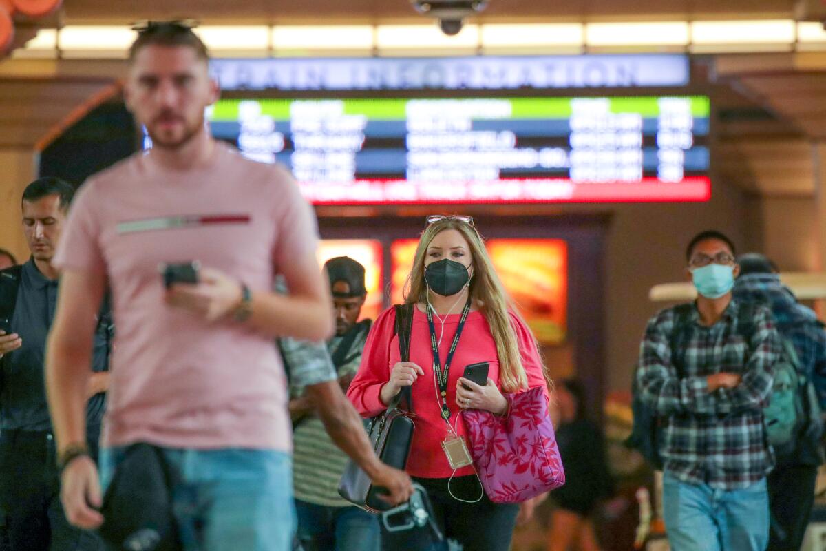 Some commuters wears masks at Union Station while others do not.