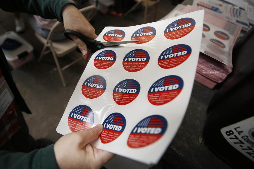 SANTA MONICA, CA - SEPTEMBER 14: Vote center lead Rachel Hadlock-Piltz, prepares "I VOTED" stickers for voters casting their ballots in a vote center at Santa Monica College as polls open Tuesday morning for Californians to decide whether Gov. Gavin Newsom should be removed from office and, if so, who should replace him in a recall election. "I really enjoy this part of the job," Rachel said. Santa Monica College on Tuesday, Sept. 14, 2021 in Santa Monica, CA. (Al Seib / Los Angeles Times).