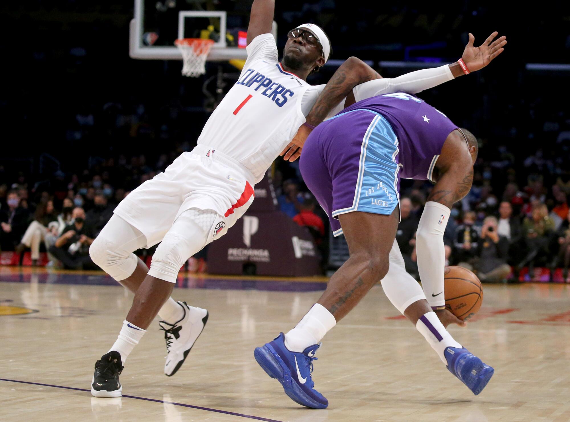 Clippers guard Reggie Jackson gets tied up with Lakers forward LeBron James.