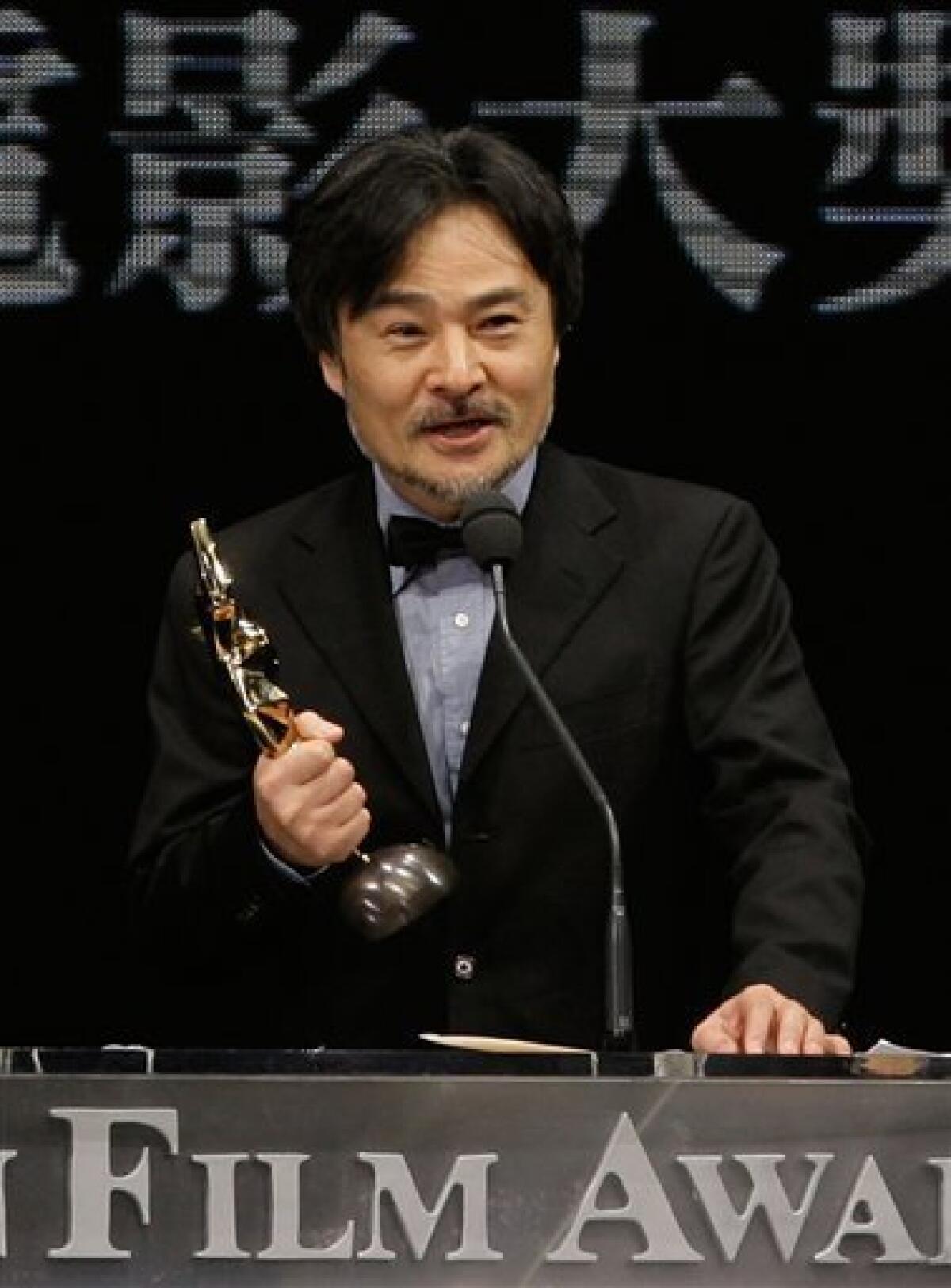 Japanese Director Kiyoshi Kurosawa celebrates with the trophy after the Dutch-Japanese-Hong Kong made movie "Tokyo Sonata" won the Best Film award at the Asian Film Awards in Hong Kong Monday, March 23, 2009. (AP Photo/Vincent Yu)