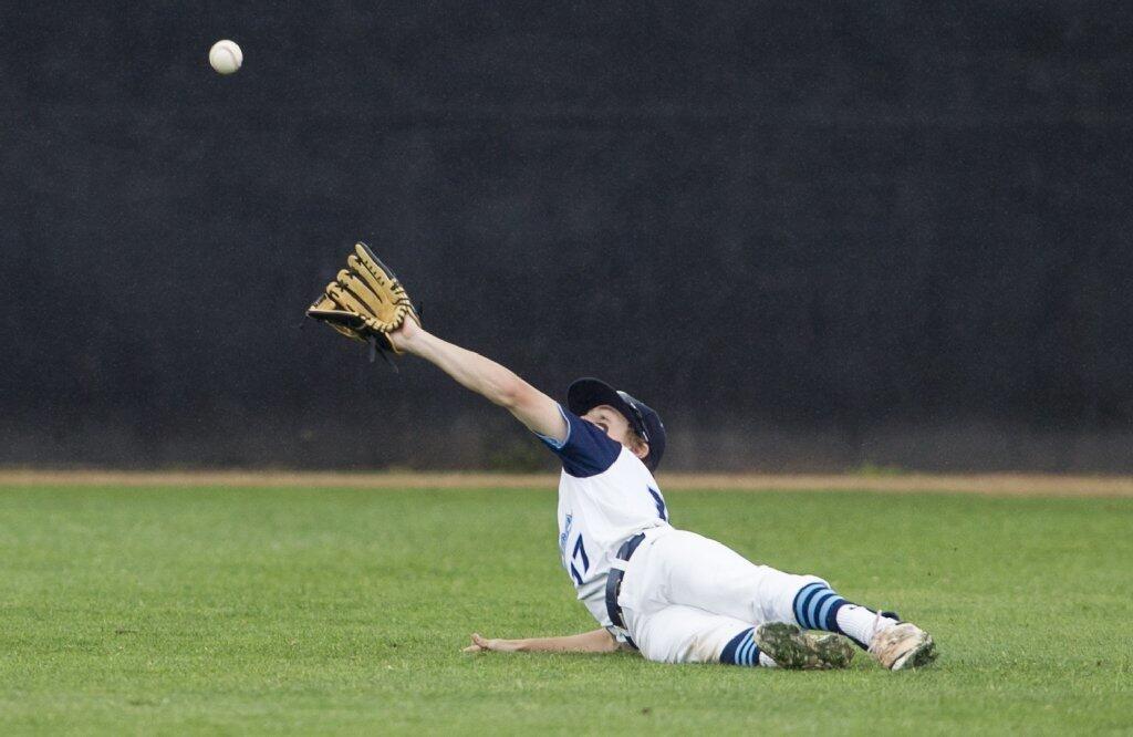 Corona del Mar's Garin Friedman slips on the grass in an attempt to catch a pop fly against Woodbridge.