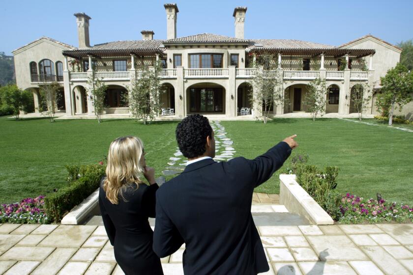 Bryan Chan 805–653–7527 –– – Realtors Mauricio Umansky, right, and Lea Jett tour the $19.7–million home at 80 Beverly Park in the gated community of Beverly Park . They are standing in the backyard.
