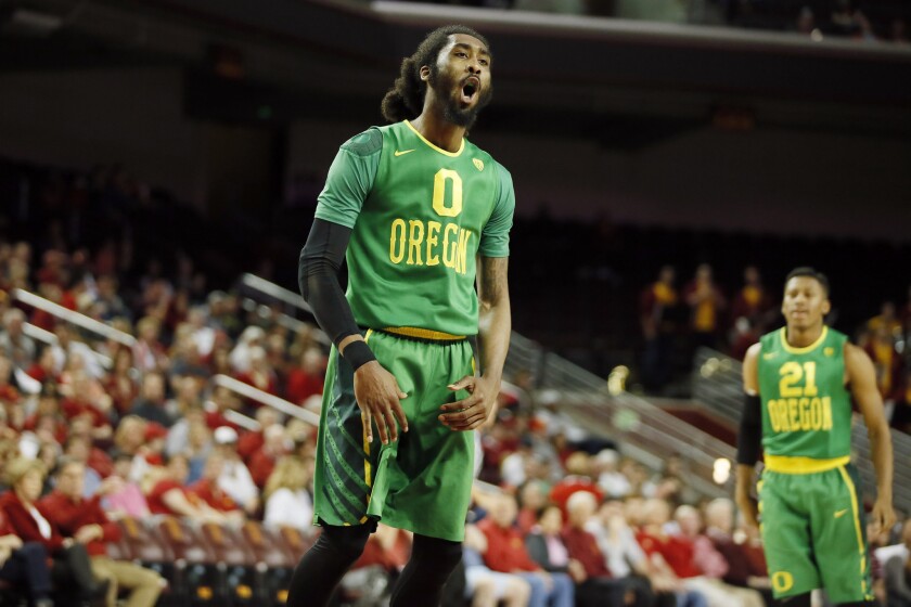 Oregon forward Dwayne Benjamin celebrates after dunking the ball over USC forward Chimezie Metu, not pictured, during the first half of a game on March 5 at Galen Center.