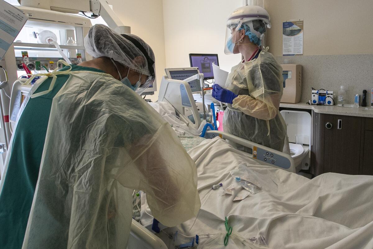 Nurses at Martin Luther King Jr. Community Hospital work on a patient brought from the COVID-19 unit into intensive care.