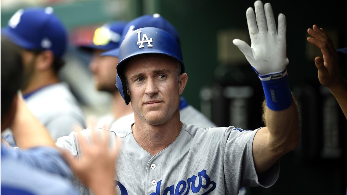 Dodgers second baseman Chase Utley gets high-fives in the dugout after he doubled and later scored on a sacrifice fly by Justin Turner during the fifth inning Saturday in Washington.