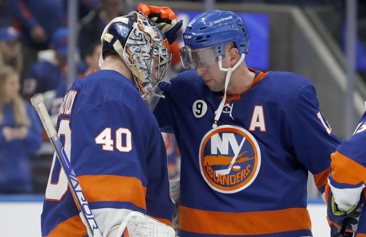 New York Islanders right wing Josh Bailey, right, and goaltender Semyon Varlamov (40) celebrate after the Islanders defeated the Winnipeg Jets in an NHL hockey game Friday, March 11, 2022, in Elmont, N.Y. (AP Photo/Jim McIsaac)