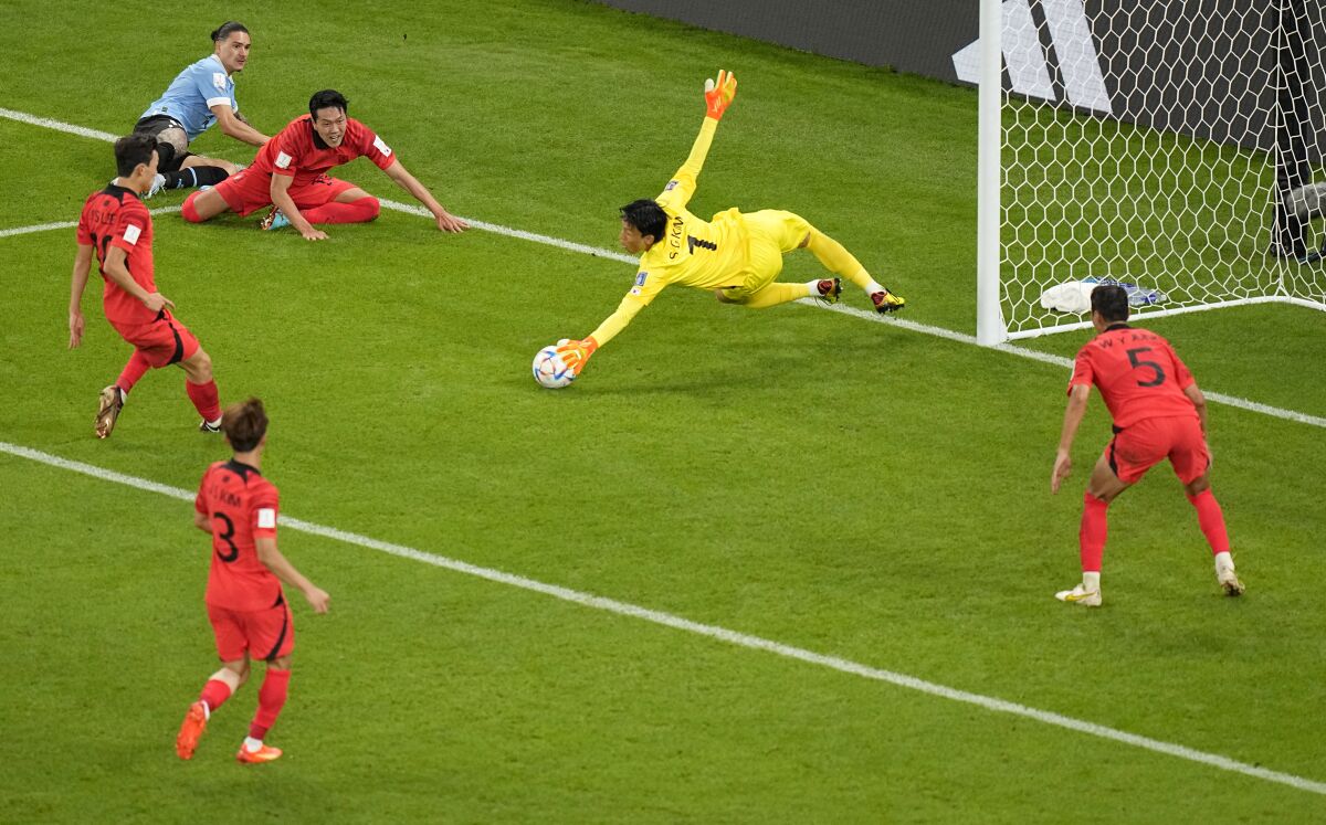 South Korea's goalkeeper Kim Seung-gyu dives to make a save a shot by Uruguay's Darwin Nunez