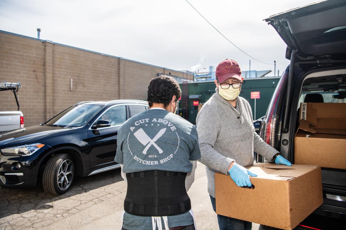 At A Cut Above butcher shop in Santa Monica, manager Jimmy Bradley helps load orders into the back of a customer's car on Wednesday.