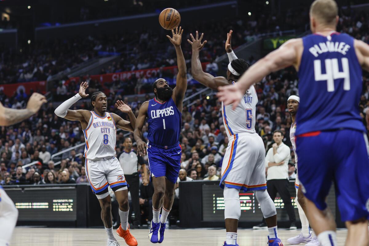 Clippers guard James Harden delivers an alley-oop pass to center Mason Plumlee during Tuesday's game.