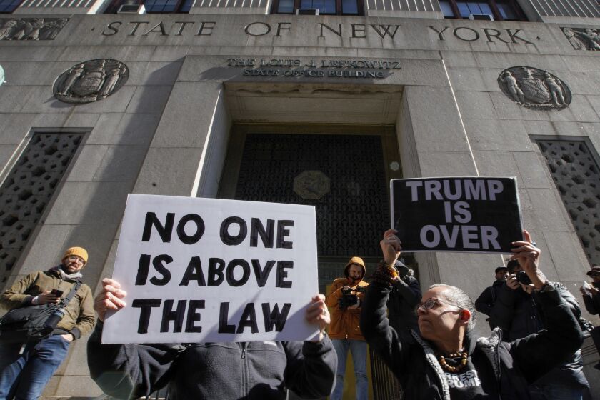Varias personas sostienen carteles que dicen "nadie está por encima de la ley" y "Trump está acabado" durante una protesta el lunes 20 de marzo de 2023 frente a la corte donde será encausado el expresidente Donald Trump en Nueva York. (AP Foto/Eduardo Munoz Alvarez)